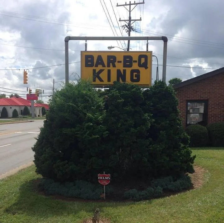Bar-B-Q King storefront with the yellow BAR-B-Q KING pylon sign under a clear blue sky