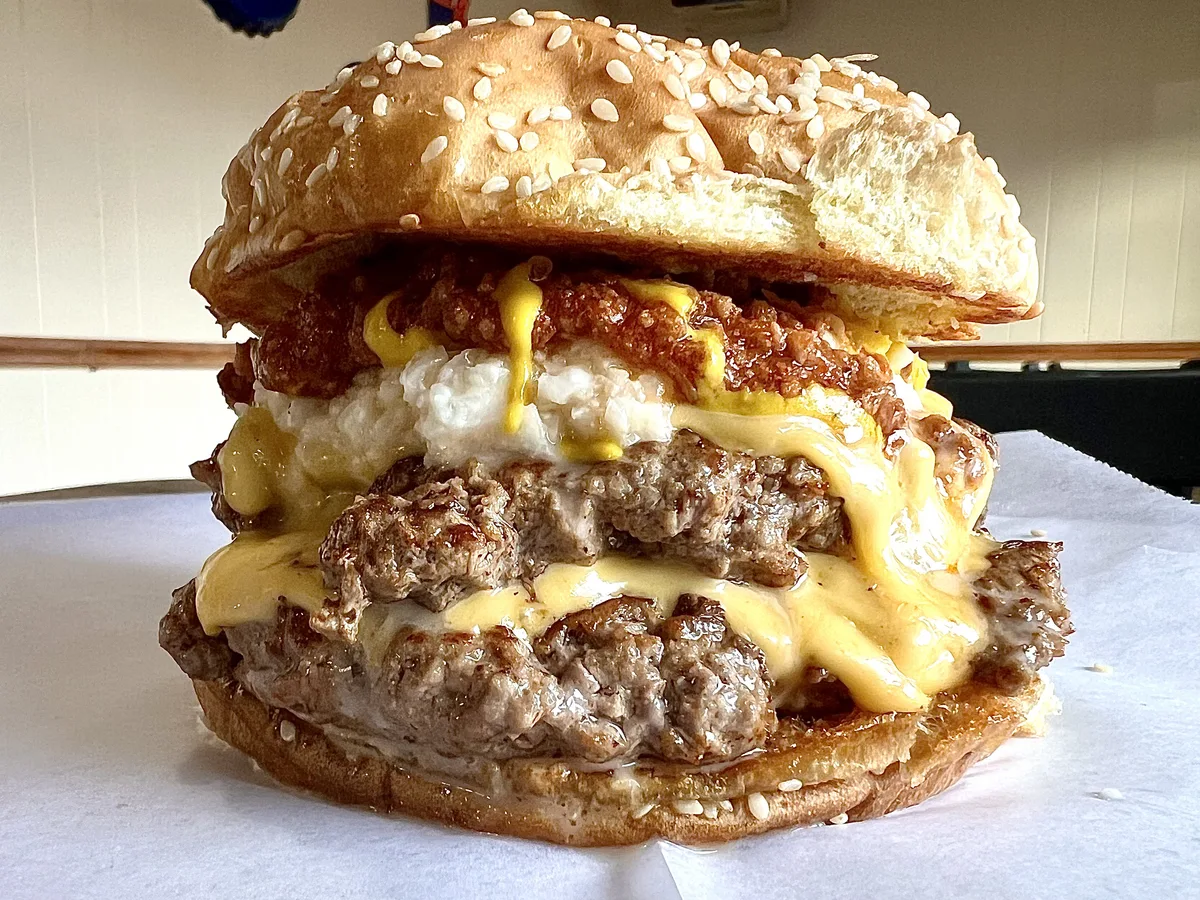 Close-up of a Double Cheeseburger King with melted cheese draped over two hand-pattied patties